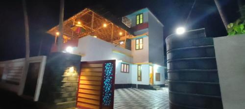 una casa di notte con un mucchio di scale davanti di Madhav Mansion Beach Resort a Varkala