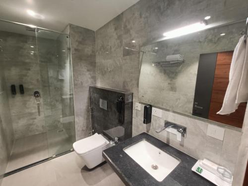 a bathroom with a sink and a shower and a toilet at HOTEL GOLDEN ORCHID in Dibrugarh