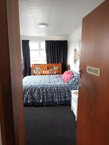 um quarto com uma cama com um edredão azul em Ahaura Hotel em Greymouth