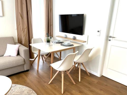 a living room with a table and chairs and a tv at Baltic Lagoon Resort - Appartement 12 in Fuhlendorf