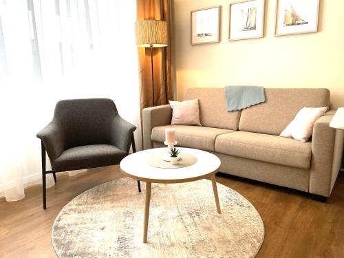a living room with a couch and a table and a chair at Baltic Lagoon Resort - Appartement 12 in Fuhlendorf
