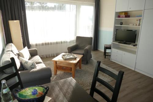 ein Wohnzimmer mit einem Sofa und einem TV in der Unterkunft Baltic Nr. 5 in Scharbeutz