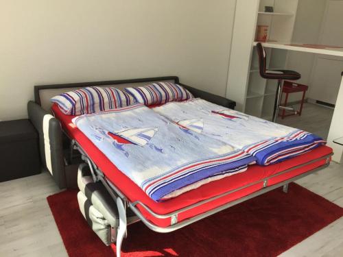 Bett in einem Zimmer mit einem roten Teppich in der Unterkunft Bellevue Nr. 15 in Scharbeutz