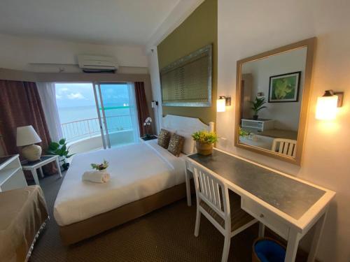 a hotel room with a bed and a table and a mirror at Seaview Deluxe@Rainbow Paradise Tg Bungah 4-6pax in Tanjung Bungah