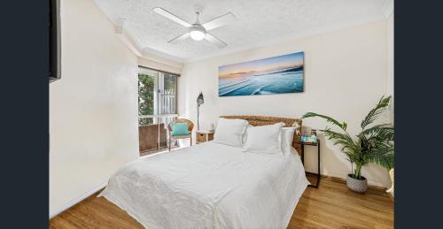 um quarto com uma cama e uma ventoinha de tecto em Bay Lodge Apartments em Gold Coast