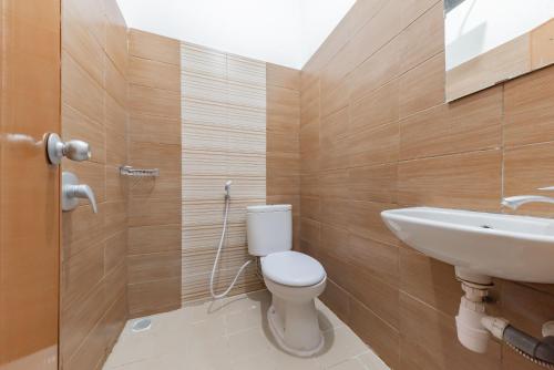 a bathroom with a toilet and a sink at Urbanview Hotel Cozy Samarinda by RedDoorz in Samarinda