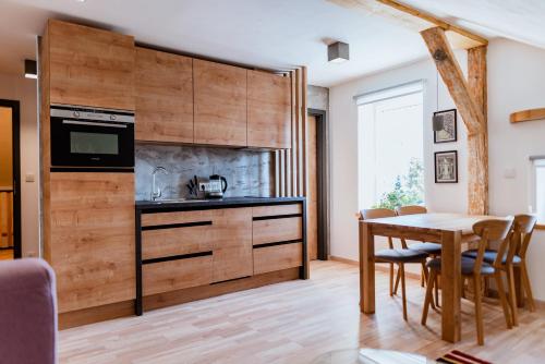 a kitchen with a table and a dining room at Apartmány Jabloneček in Jablonec nad Jizerou
