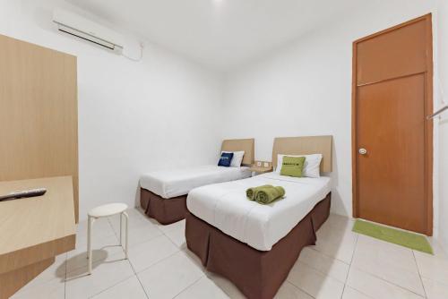 Кровать или кровати в номере Urbanview Hotel Cozy Samarinda by RedDoorz