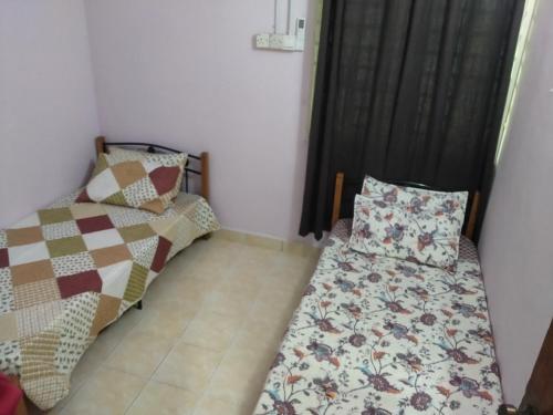 a bedroom with two beds and a pillow at Ali Homestay Desa Permai Bukit Kuang in Cukai