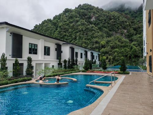 a swimming pool in front of a building with a mountain at Cozy Suite with 270 Degree Mountain and Theme Park Views in Ipoh