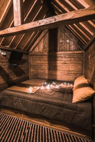 a bed in an attic with lights on it at Singgasana Villa & Resto in Bedakah