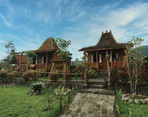 een paar huizen in een veld met een tuin bij Singgasana Villa & Resto in Bedakah