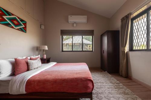 a bedroom with a large bed and a window at Emerald Greens by VEO - Part of StayVista in Lonavala