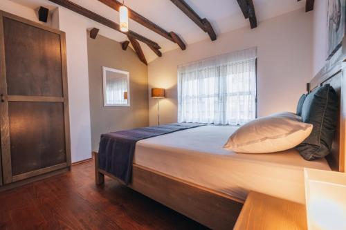a bedroom with a large bed with a window at Kuca za odmor M11 in Kupres