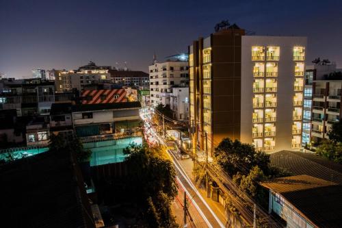 a view of a city at night with buildings at The Aim Sathorn Hotel in Bangkok