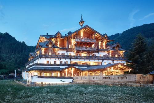 une grande maison en bois au sommet d'une montagne dans l'établissement Grossarler Hof Superior, à Grossarl