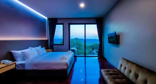a hotel room with a bed and a large window at The Riva Vientiane Hotel in Vientiane