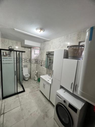 a bathroom with a refrigerator and a toilet and a sink at İstanbul havaalanı yanında deniz kıyısına sahip odalar in Arnavutköy