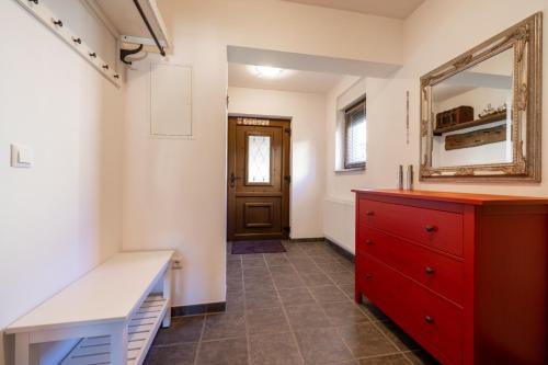 a bathroom with a red dresser and a mirror at Kuca za odmor M11 in Kupres
