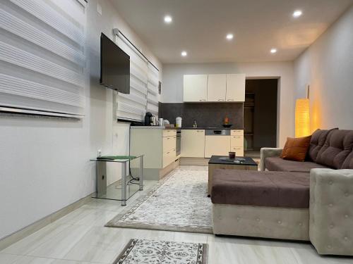 a living room with a couch and a kitchen at Apartman Ćuprija in Cazin