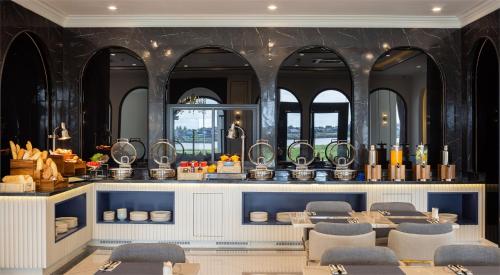 a dining room with a table and chairs and mirrors at Eastin Hotel Vientiane in Vientiane