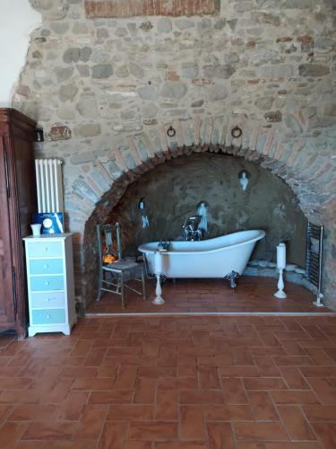 y baño con bañera en una pared de piedra. en The Bergamot, en Tursi