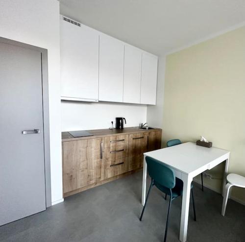 a kitchen with white cabinets and a table and chairs at Horský apartmán Achát in Janov nad Nisou