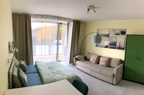 a living room with a couch and a large window at Horský apartmán Achát in Janov nad Nisou