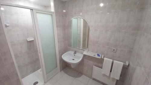 La salle de bains est pourvue d'un lavabo, d'une douche et d'un miroir. dans l'établissement Motel Montecarlo, à Teo