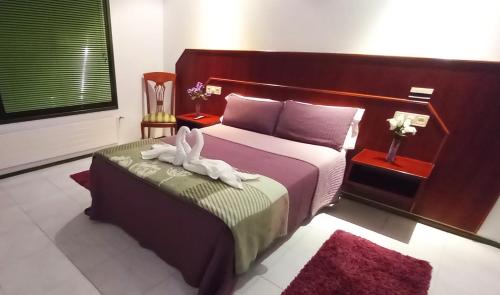 a bedroom with a bed with two towels on it at Motel Montecarlo in Teo