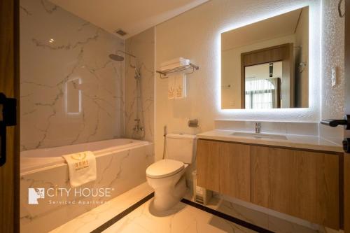 ein Badezimmer mit einem Waschbecken, einem WC und einem Spiegel in der Unterkunft Cityhouse S Home in Ho-Chi-Minh-Stadt