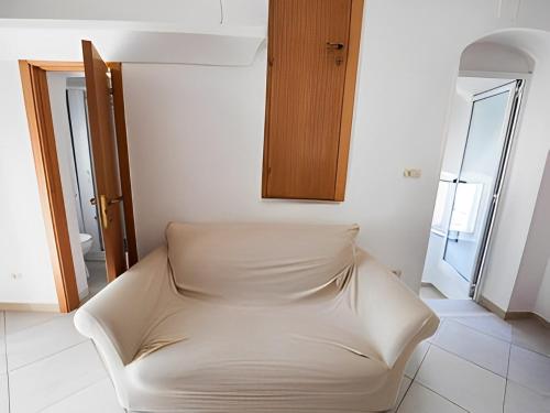 un divano bianco in una stanza con finestra di Monolocale finemente ristrutturato a Ostuni