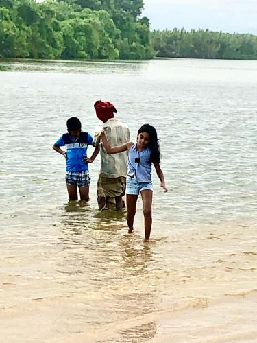 a man and two children walking in the water at Seth Villa by Magampura Resorts in Tangalle