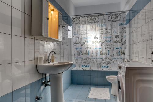 a bathroom with a sink and a shower curtain at ΔΙΑΜΈΡΙΣΜΑ ΜΕΝΤΗΣ in Igoumenitsa