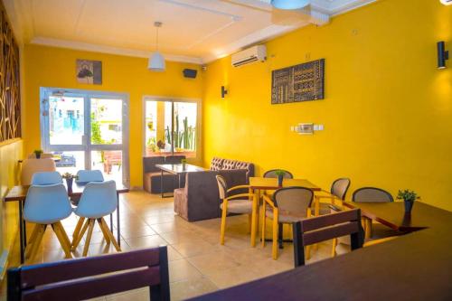 un restaurant avec des murs jaunes, une table et des chaises dans l'établissement krEMLin, à Douala