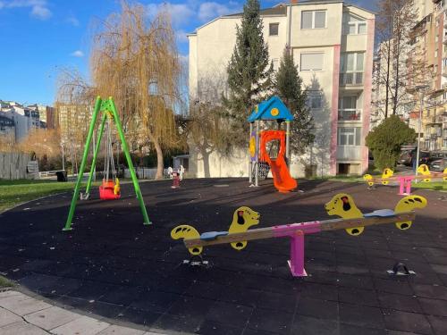 a park with a playground with a skateboard and swings at Idealapartments LLC 8 in Pristina