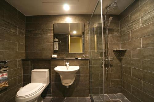 a bathroom with a toilet and a sink and a shower at I-Jin Hotel in Jeju