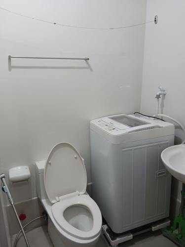 a bathroom with a toilet and a sink at 1 BR with poolside view balcony in Manila