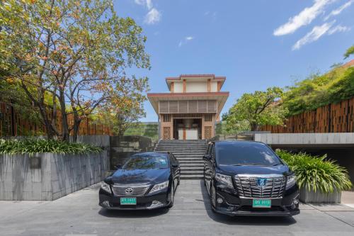 two cars parked in front of a building at Cape Nidhra Hotel in Hua Hin