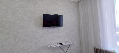 een flatscreen-tv die aan de muur hangt bij Аэропорт 10 минут жк Будапешт163 in Astana