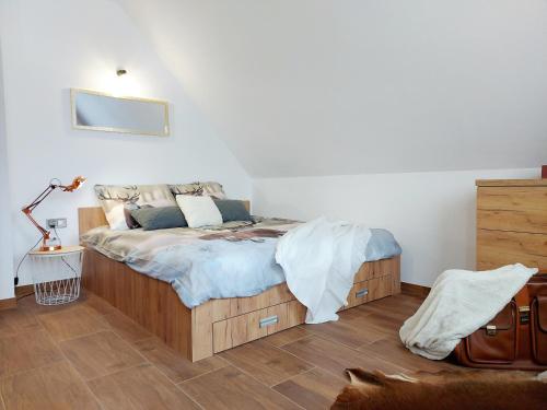 1 dormitorio con 1 cama y suelo de madera en Borówka- u podnóża gór, nad jeziorem Czorsztyńskim en Dębno