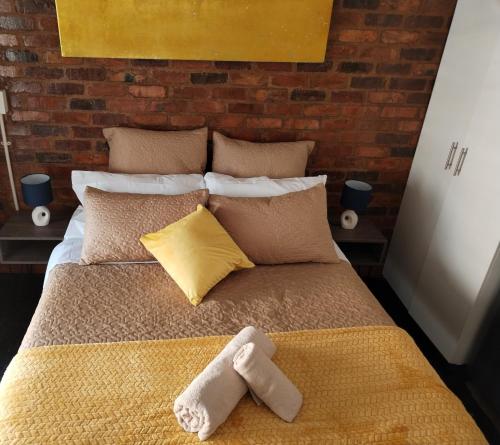 a bed with a towel on top of it at Maboneng Precinct Johannesburg - Craftsmenship Apartments in Johannesburg