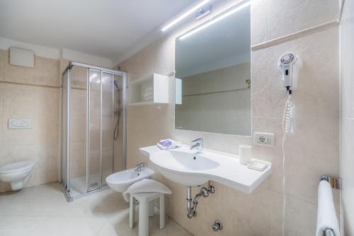 a bathroom with a sink and a shower and a toilet at Eden Apartments in Siusi