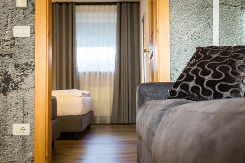 a hotel room with a couch and a window at Eden Apartments in Siusi