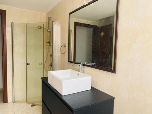ein Badezimmer mit einem weißen Waschbecken und einem Spiegel in der Unterkunft Luxury & Big Families Apartment (7 Min f TLV) in Bat Yam