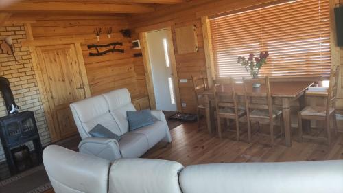 uma sala de estar com um sofá e uma mesa numa cabina em Padvarių sodyba ant tvenkinio kranto su pirtimi 
