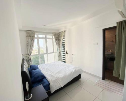 a bedroom with a bed with blue pillows and a window at Vesta Homes, KSL Residences Taman Daya, Johor Bahru in Johor Bahru