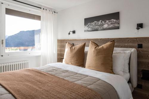 a bedroom with a bed with pillows and a window at La Ruinette - Modern 1 Bed, 3 Mins From Cable Car in Verbier