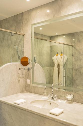 a bathroom with a sink and a mirror at La Maison Arabe Hotel, Spa & Cooking Workshops in Marrakech