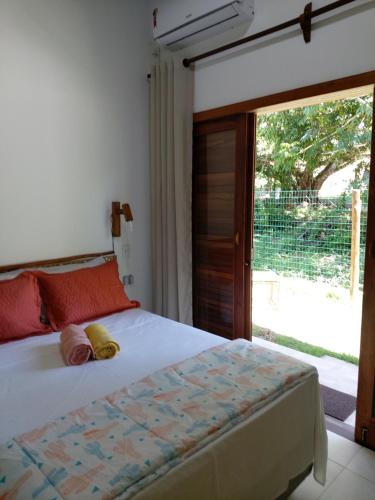 1 dormitorio con 1 cama y puerta corredera de cristal en Cafofo de Dri en Ilha de Boipeba